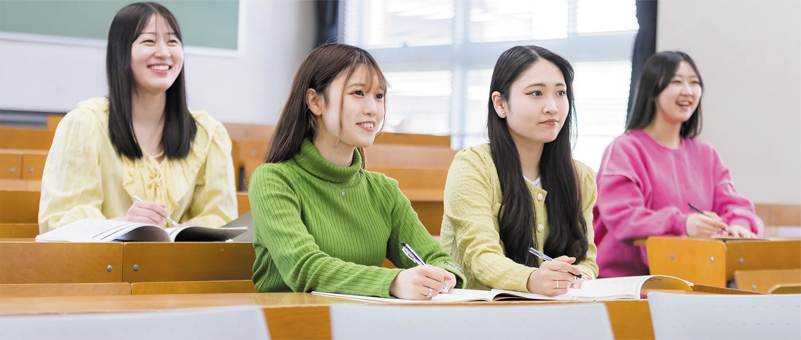 教室で楽しそうに授業を受ける学生たち。明るく安心できる学びの雰囲気が伝わるキャンパスライフの一場面。