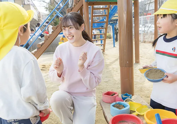 学生が園庭で園児と楽しく遊んでいる様子。